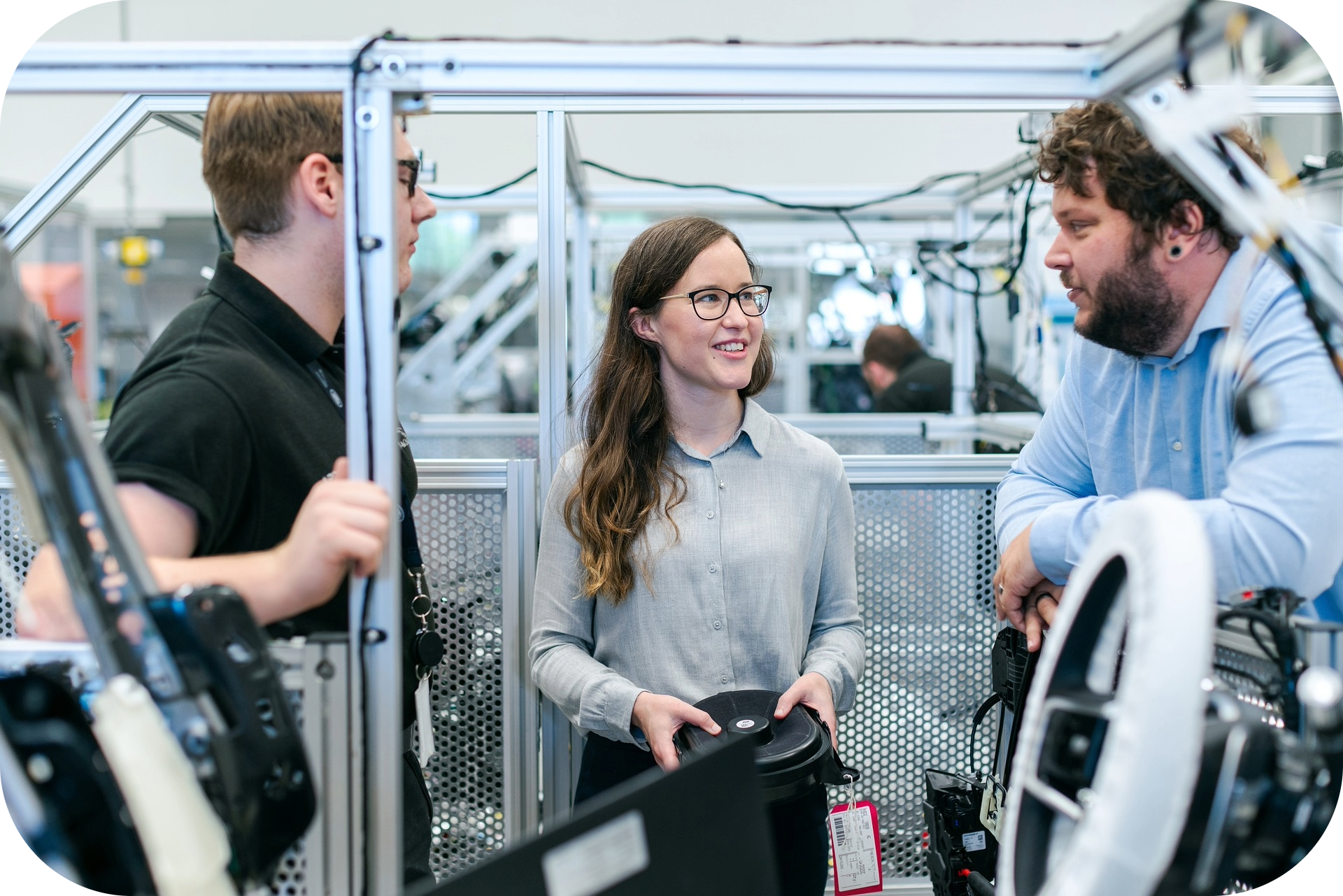Manufacturing team collaborating on the production floor while inspecting a finished part